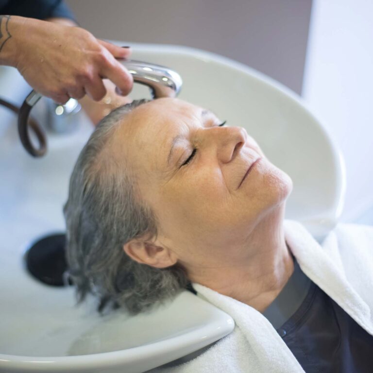 Signora anziana che si fa lavare i capelli